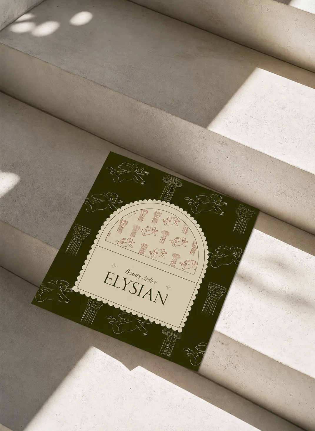 Elysian olive print card resting on sunlit travertine steps