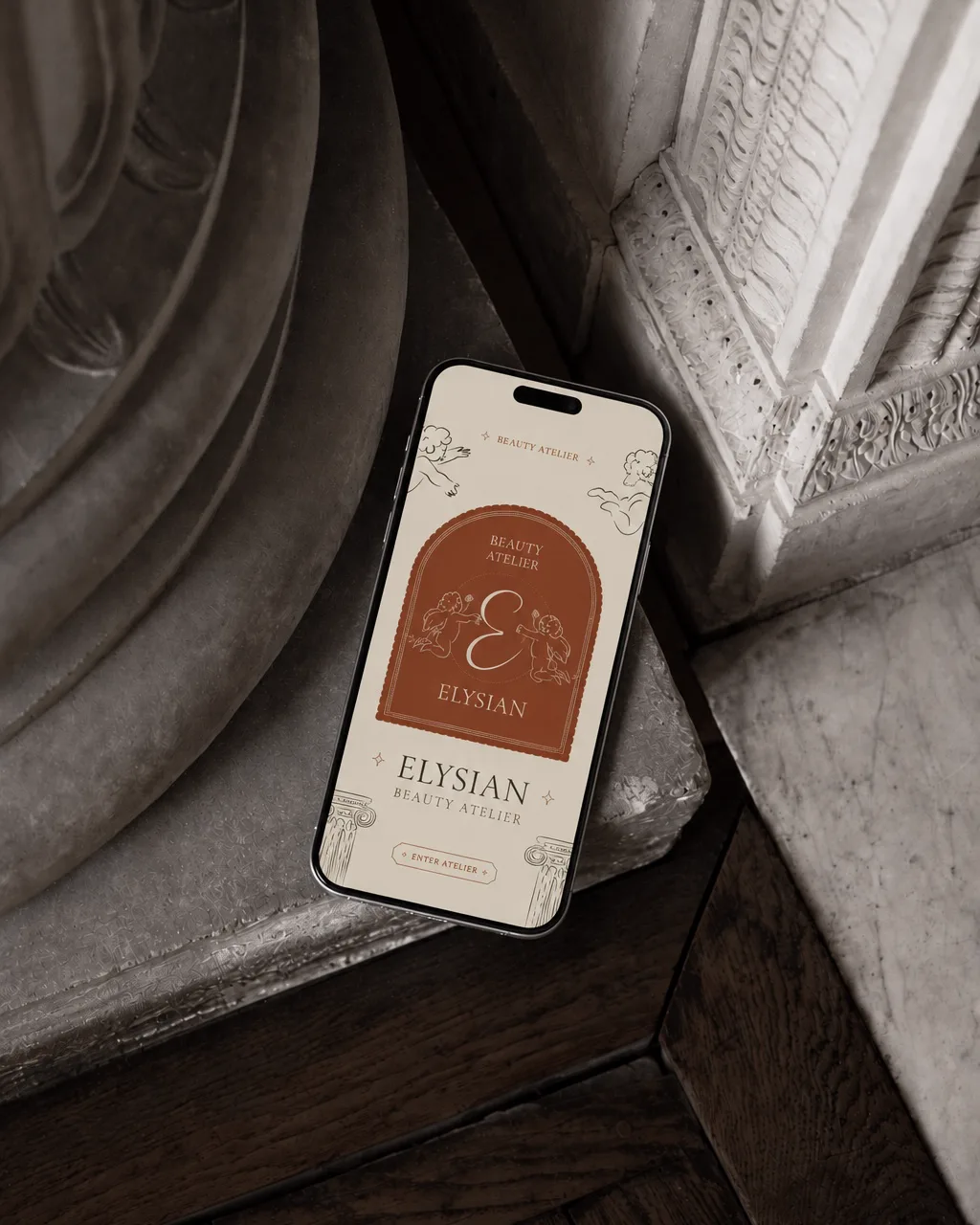 Elysian mobile app rendered on iPhone resting against classical stone column base