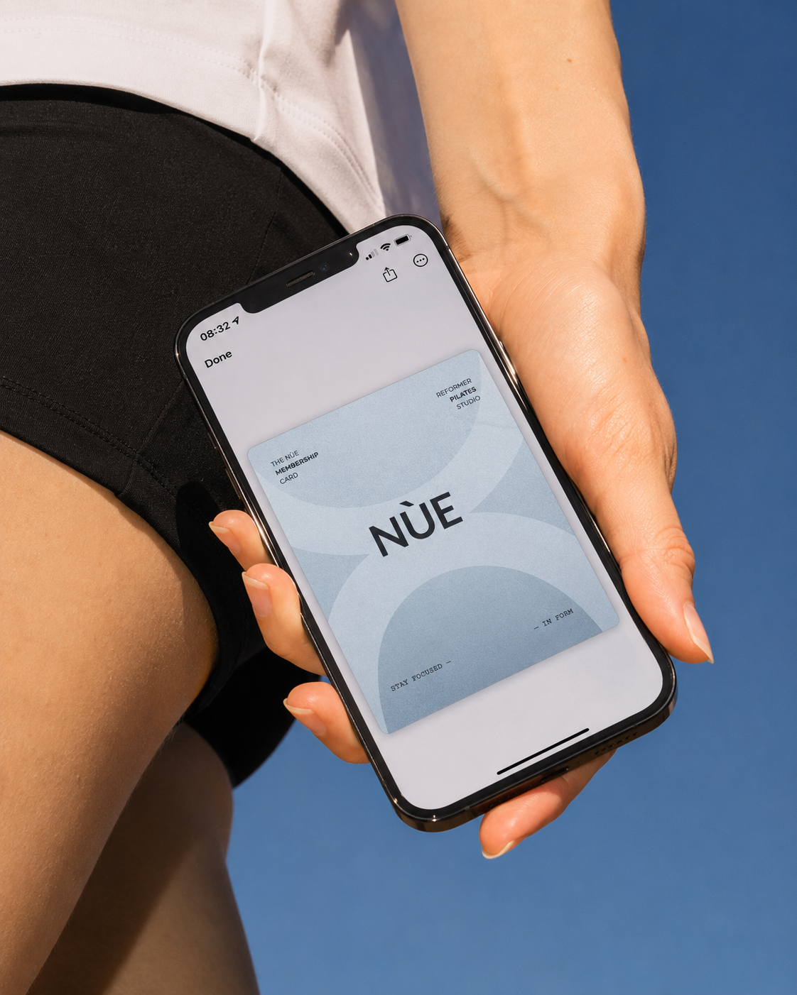 NÙE membership pass in Apple Wallet held in hand