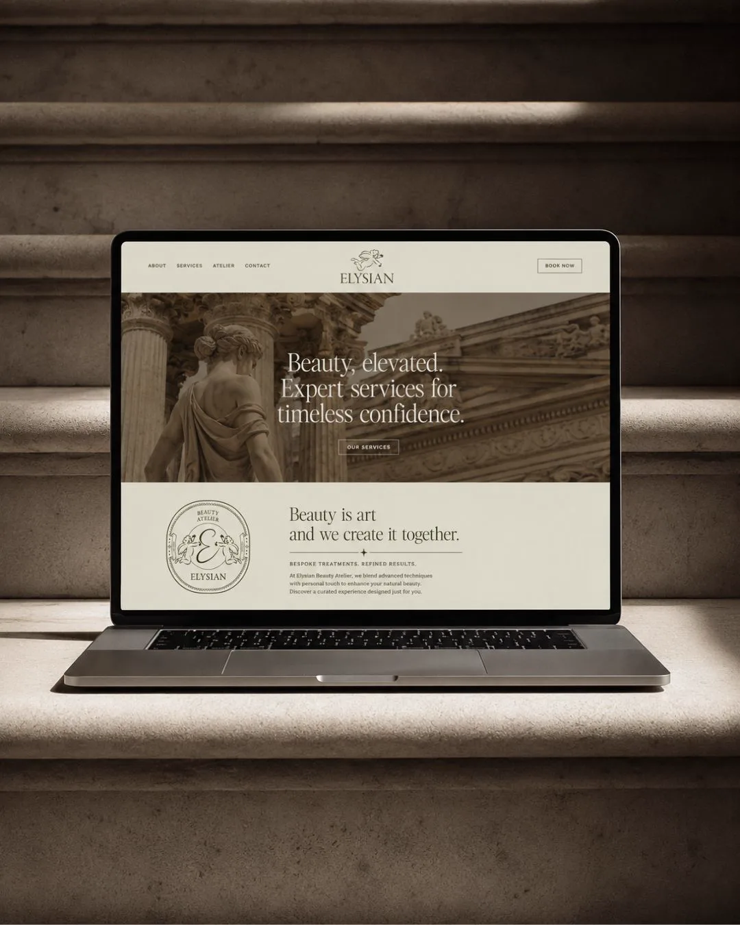Elysian website shown on laptop resting on sunlit stone steps